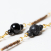 Long golden necklace with black and golden beads detail