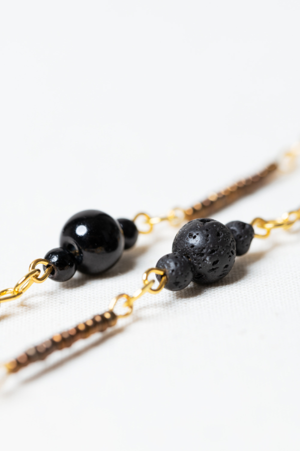 Long golden necklace with black and golden beads detail