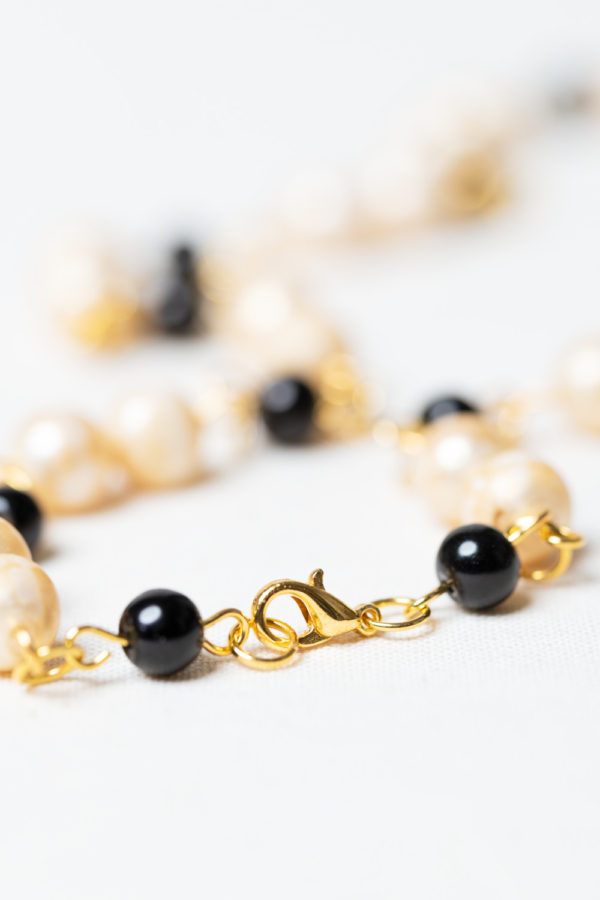 Golden necklace with vintage pearls and black glass beads closure