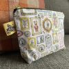 Discover the Wash Bag - Bear Portraits, a compact, zippered pouch designed for everyday convenience. This stylish wash bag features charming bear portraits alongside whimsical animals like an owl and a fox, all set against textured gray and orange striped fabric. Perfect for travel or daily use, this wash bag includes a distinctive tag with a horse and carriage logo design.