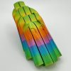 Discover a vibrant rainbow-colored plastic structure featuring interlocking curved segments stacked in an eye-catching design. This captivating object showcases a seamless transition from green at the base, shifting through orange and blue in the center, and culminating with green on top. Perfectly set against a plain background, this colorful masterpiece is ideal for those seeking unique decorative accents or perfect photography subjects.