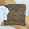 Discover the exquisite craftsmanship of our handmade woven herringbone patterned pouch. This distinctive accessory showcases an elegant blend of shades in brown, green, and yellow. Featuring a secure zipper closure at the top, this versatile pouch is perfect for organizing your essentials. Captured beautifully on a rustic wooden surface, it features a unique tag that proudly bears the name The Crafty Weaver. Explore more artisanal pouches and elevate your accessory collection with this stylish must-have!.