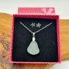 Elevate your style with this elegant silver necklace featuring a frosted sea glass pendant, perfectly paired with matching silver flower-shaped earrings. Presented in a charming pink polka dot gift box with a satin bow, this stunning jewelry set makes an ideal gift for her. Displayed on a rustic wooden surface, these handcrafted accessories add a touch of coastal charm and timeless beauty to any outfit. Perfect for special occasions, birthdays, or as bridesmaid jewelry gifts.