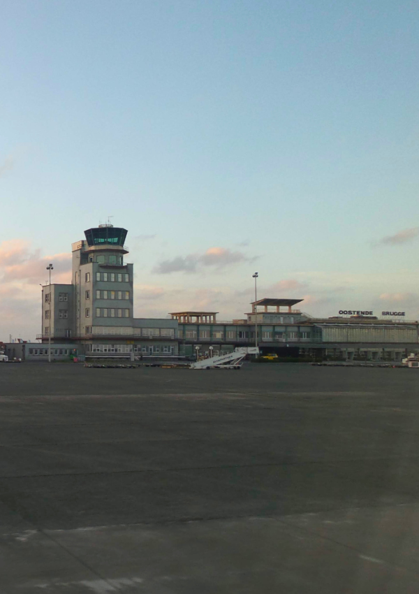 De tarmac van de luchthaven van Oostende. Op de achtergrond het luchthavengebouw.
