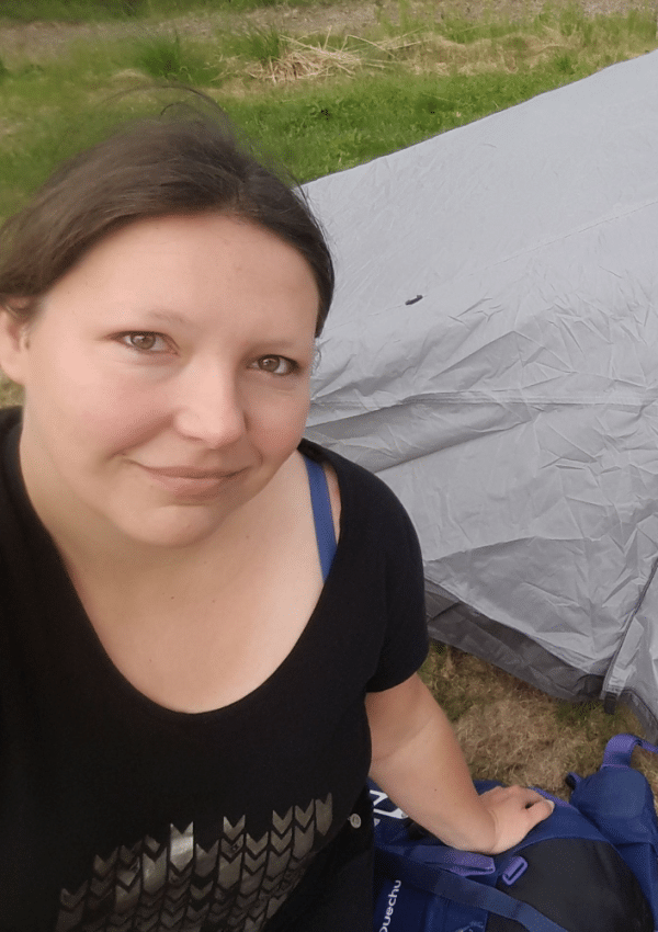 Heidi zit voor een grijze tent, in Zweeds Lapland.