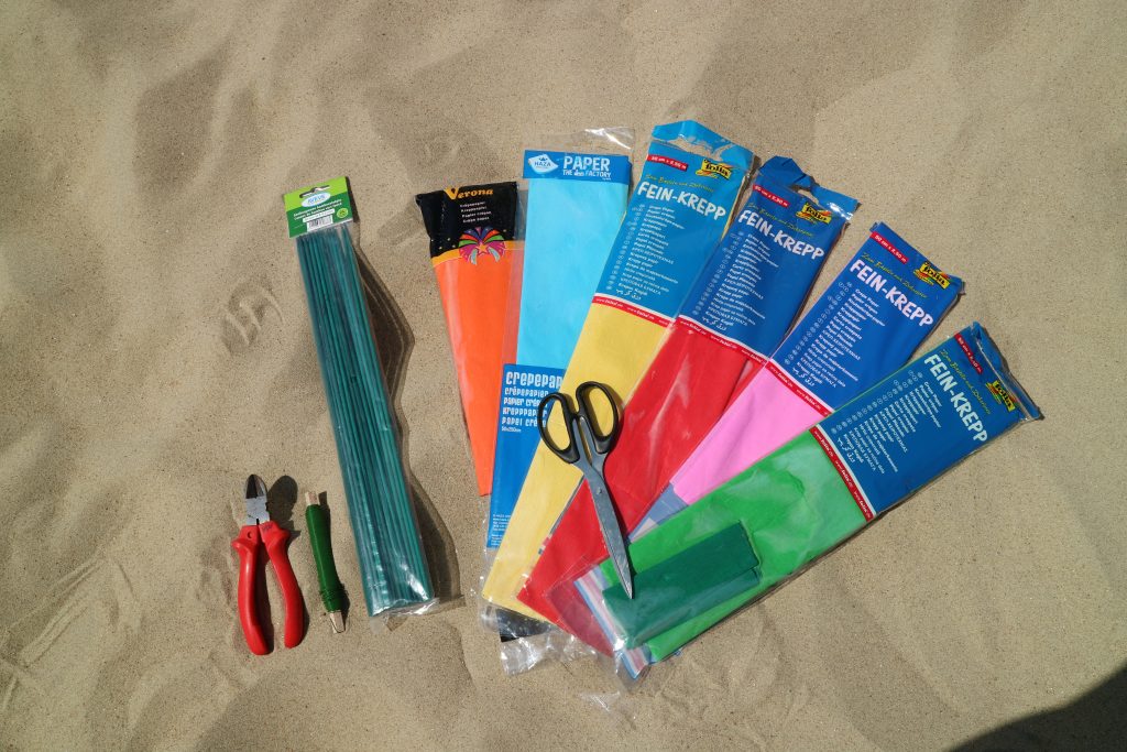 Benodigdheden strandbloemen maken: crepepapier, ijzerdraad, groene stokjes,...