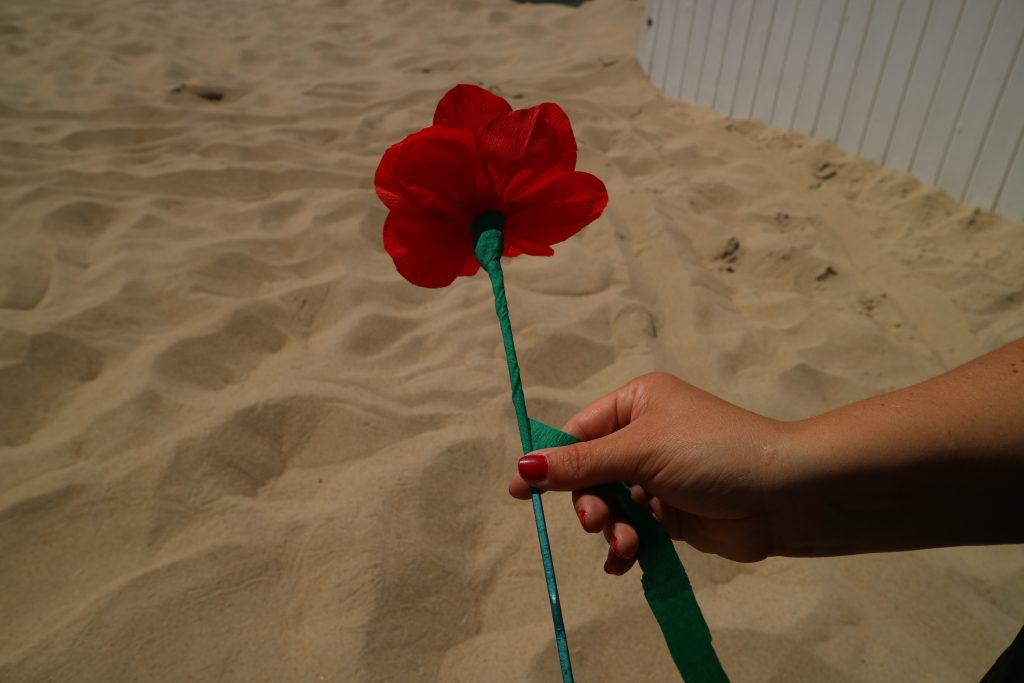 Een papieren strandbloem met een groene steel.