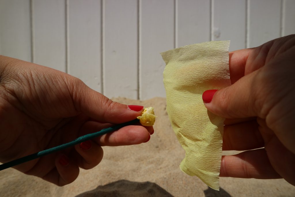 Neem een klein vierkantje van een restje crepepapier. Houd een wattenbol (of, mijn persoonlijke voorkeur, een propje van crêpepapier) tegen de bovenkant van het plantenstokje.