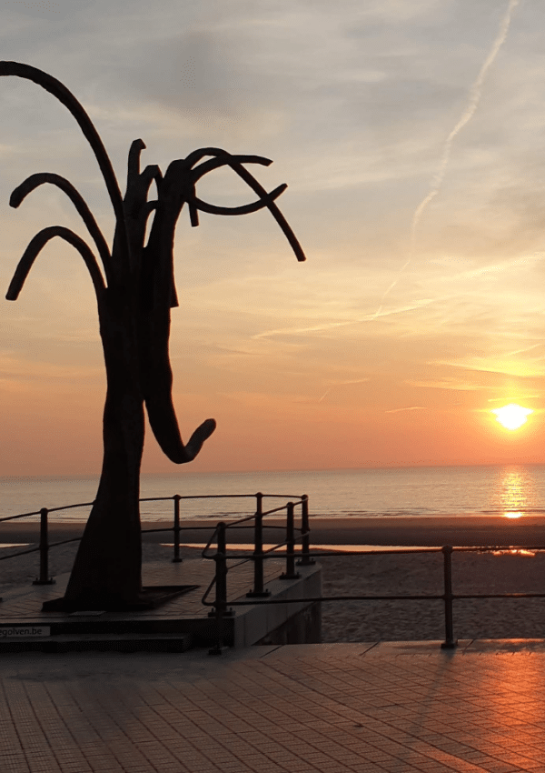 Een prachtige zonsondergang bij het kunstwerk Dansende Golven op de zeedijk van Oostende, ter hoogte van het Kursaal.