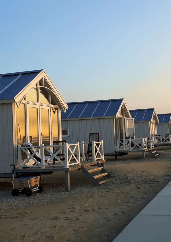 Op het strand staan een tiental strandhuisjes met een verhoogd terras.