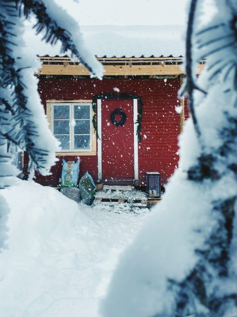 Cozy, red barrack used as chicken coop. Completely covered with snow.