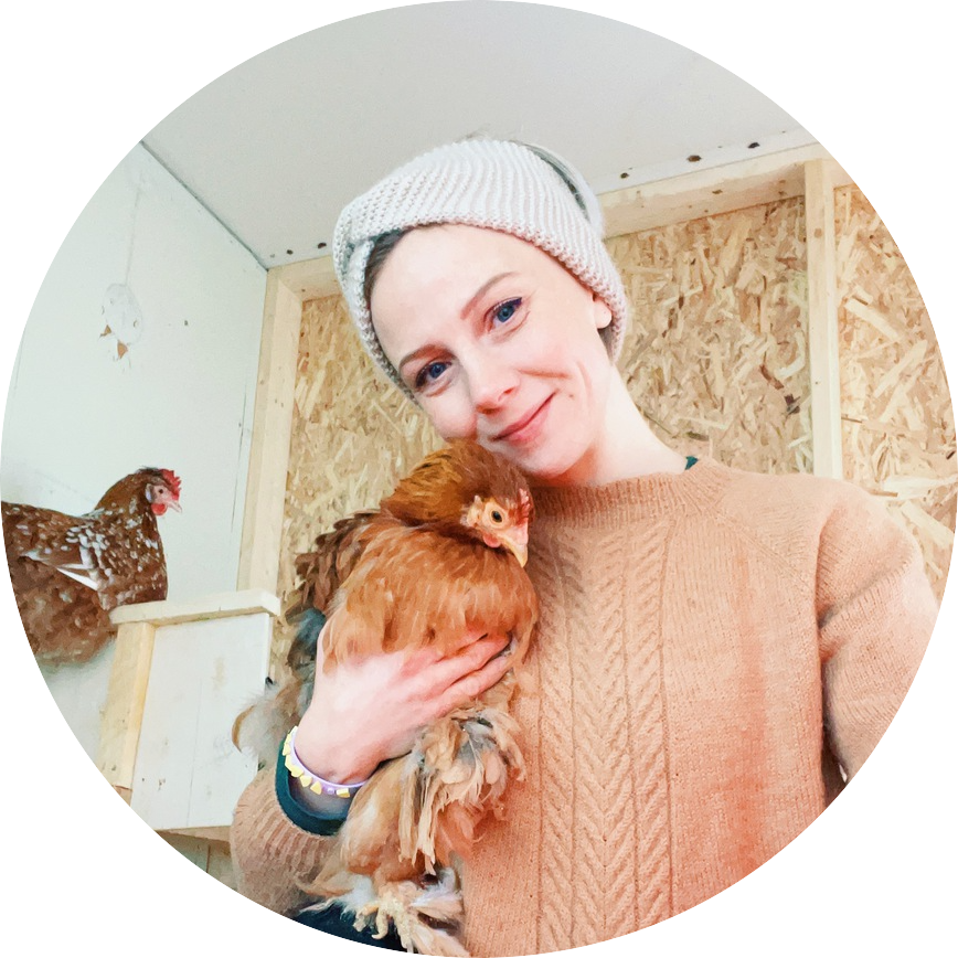 Trine Marie Johansen, writer of the heimastead blog, holding a chicken.