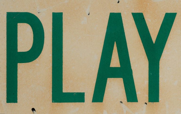 Close up of old tennis sign saying play