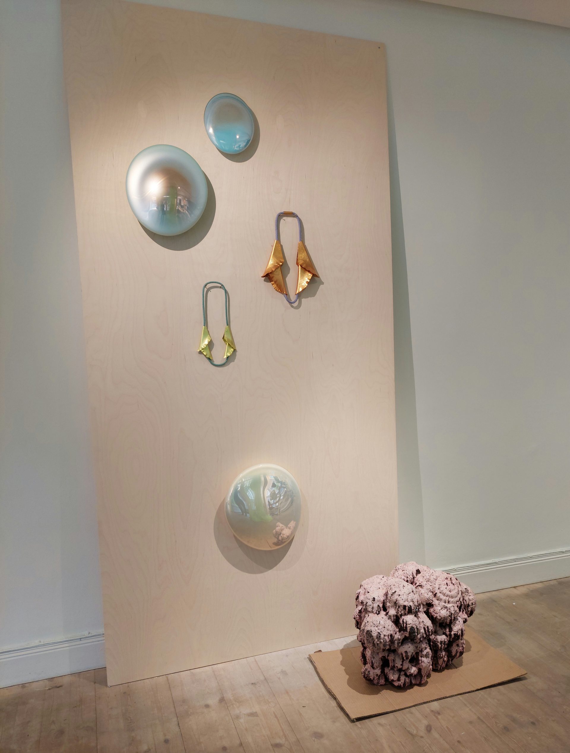 Utställningsvägg med konsthantverk i metall, glas och keramik
