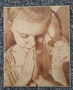 trätavla med glödritat motiv, liten flicka som ber till Gud
