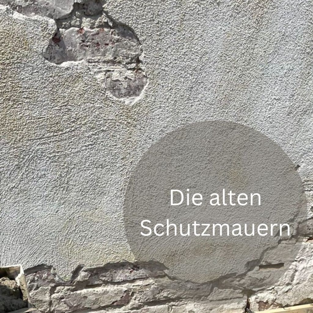 Auf dem Bild sieht man ein Stück Mauer und die Aufschrift Die alten Schutzmauern.