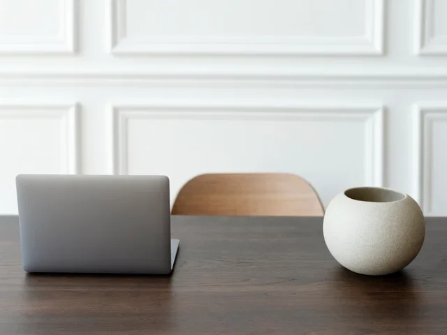 En stängd laptop och en rund keramikvas sitter på ett mörkt träbord framför en trästol och en vit panelvägg och visar upp den prydliga miljön som kontorsstädning i Göteborg har skapat. En stängd laptop och en rund keramikvas sitter på ett mörkt träbord framför en trästol och en vit panelvägg och visar upp den prydliga miljön som kontorsstädning i Göteborg har skapat.
