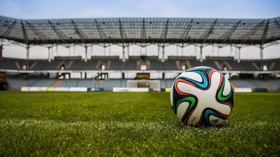 En fotball som ligger på en gressmatte på en stadion