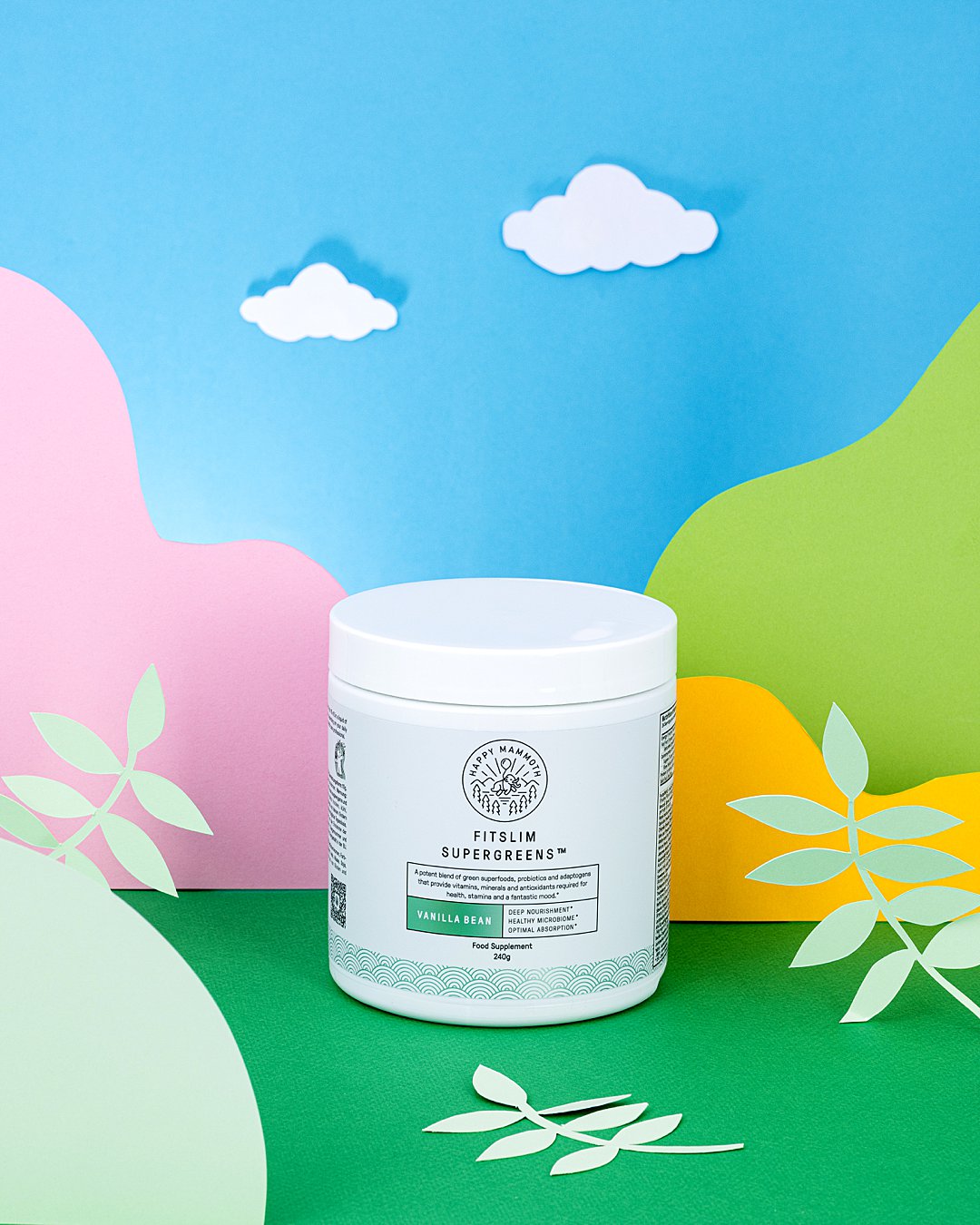 Colourful commercial photography with paper art for Happy Mammoth vitamin supplements. Styled health supplement product still life photography by HIYA MARIANNE photo production studio.