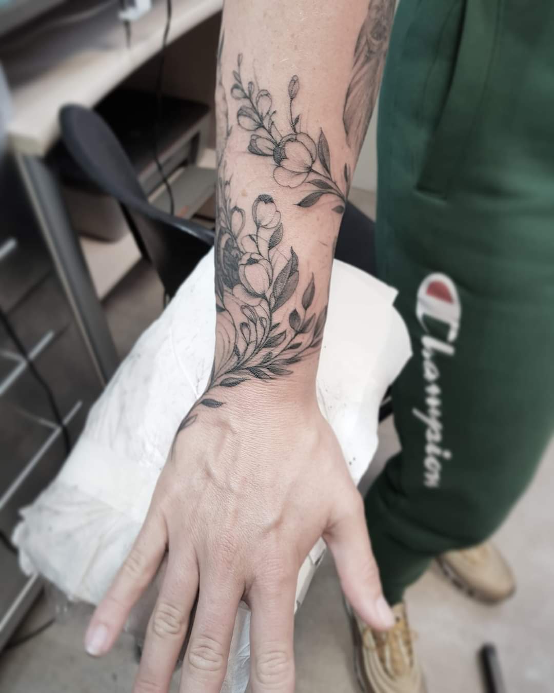 Singleneedle flowers on womans hand tattoo