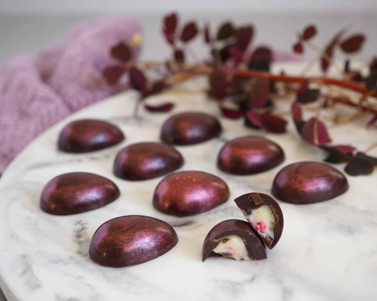 Fyldte chokolader med hvid chokolade ganache og frysetørrede hindbær
