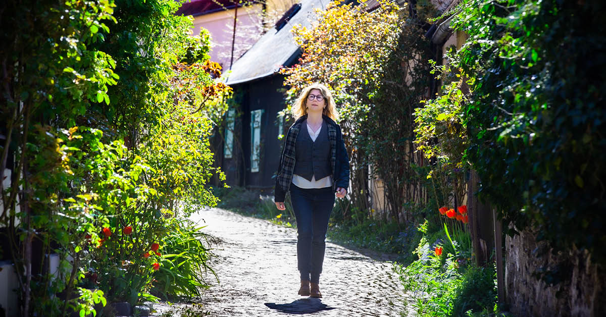 Bild på Louise Hoffman Borgö som är regionens världsarvssamordnare gåendes inne i Visby innerstad