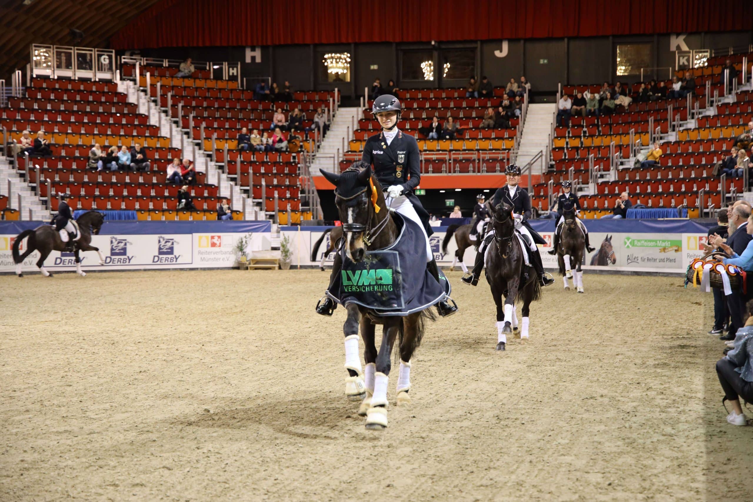 Helen Erbe und ihr Wallach Carlos FRH auf der Ehrenrunde nach ihrem Sieg im Grand Prix Special in der Halle Münsterland. "AGRAVIS Raiffeisen AG"