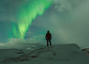 man står under ett norrsken i kiruna