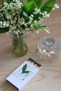 Tändsticksask och blommor på bord