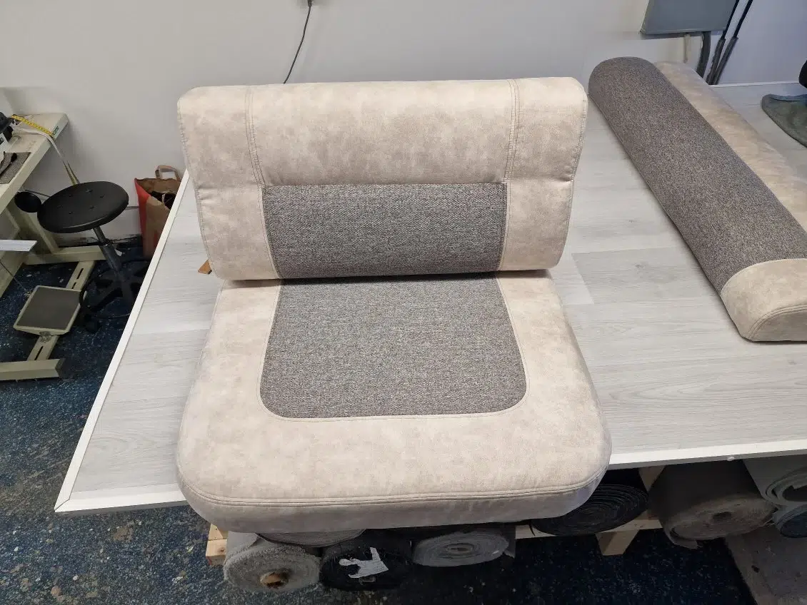 Skräddarsydd husbilsinredning med fokus på att skapa en trivsam miljö genom nya dynor och materialval.