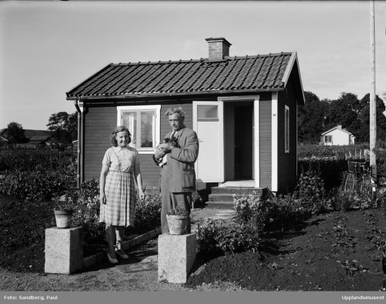 Tunabergs koloniträdgårdsförenings ordförande, ombudsman Karl Axel Åberg med fru Lagerkvist framför hennes kolonistuga i Tunabergskolonin, Tuna backar