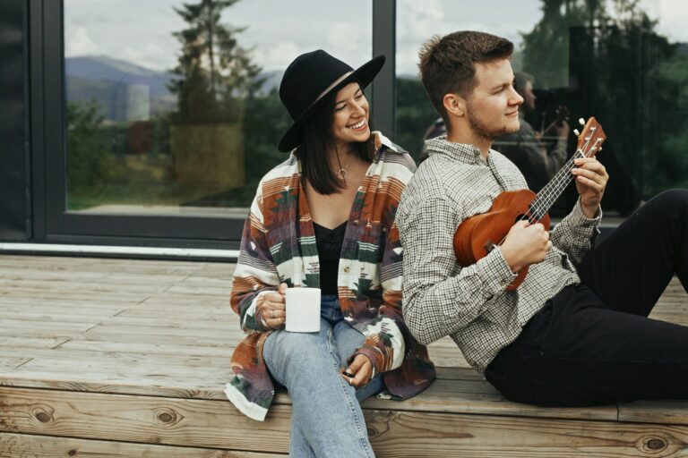 Hipster man playing on ukulele for his beautiful stylish woman