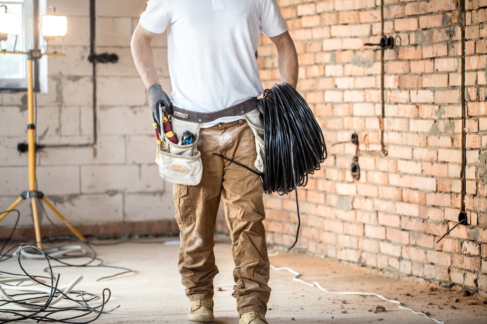 Electrician with tools, working on a construction site. Repair and handyman concept.