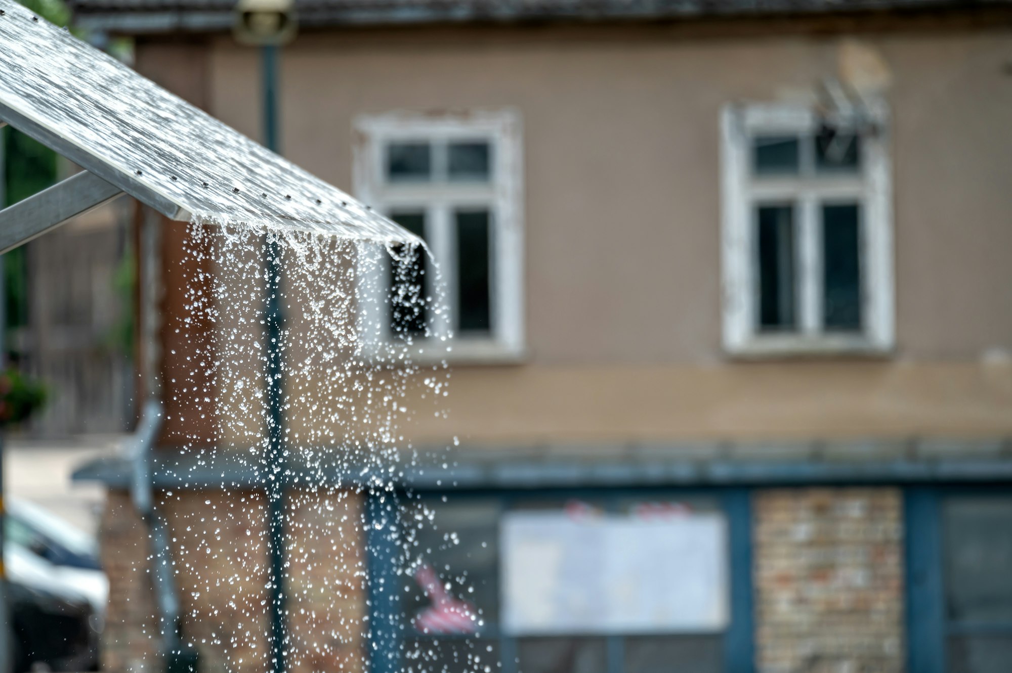 Rain dripping from awning in front of building. Background with selective focus and copy space