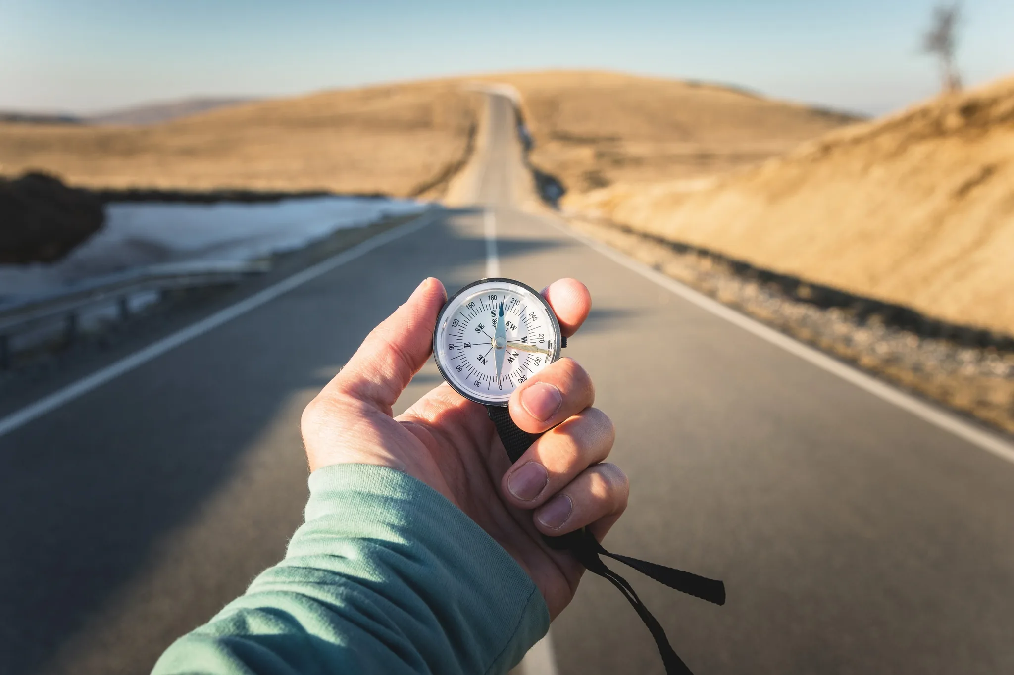 A hand holding a compass on the way: direction in leadership development