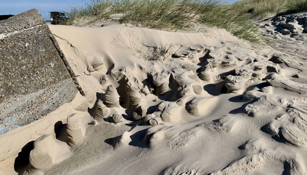 Vinden har laget små skulpturer i sanden