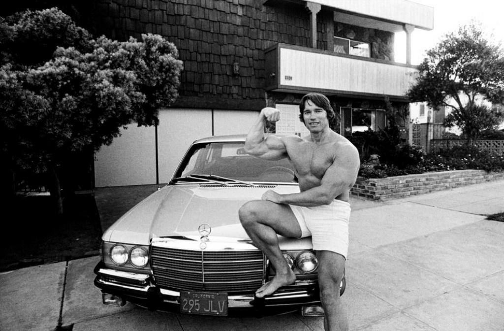 Personajes singulares y sus coches: Arnold Schwarzenegger con su Mercedes W116 frente a su casa en Los Ángeles en 1977 | Thomas Hoepker