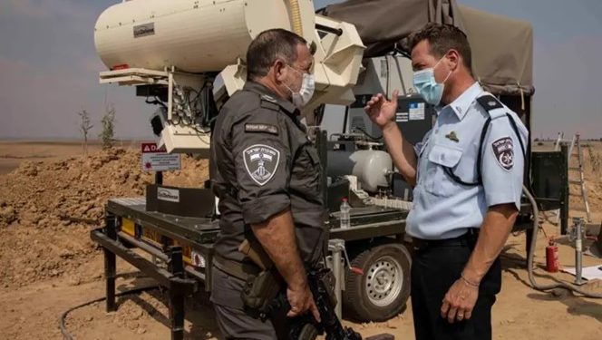 Politibetjenter sjekker en enhet ved et lasersystem som har som mål å avskjære brannballonger, nær Gaza-grensen. Foto: ISRAEL POLICE.