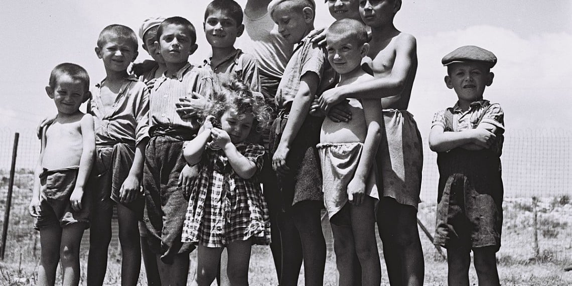 En liten gruppe foreldreløse jødiske barn som overlevde utryddelsesleirene i Europa. Foto fra flyktningleiren Atlit (Palestina) 14. juli 1944 - National Phpto Collection, Goverment Press Office / https://commons.wikimedia.org/wiki/File:Flickr_-_Government_Press_Office_%28GPO%29_-_A_group_of_orphans,_survivors_of_the_holocaust,_atthe_reception_camp_in_Atlit..jpg.