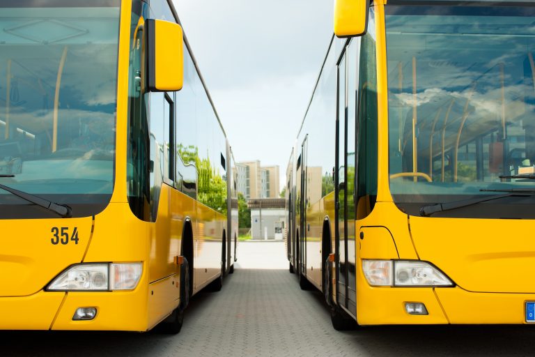 Busse parken nebeneinander auf dem Bushof