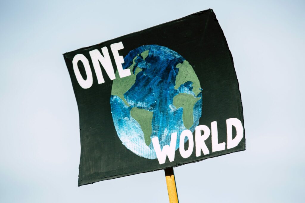 Schild auf Demo "One World"