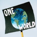 Schild auf Demo "One World"