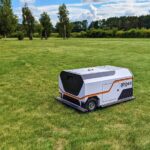 Ein mobiler Roboter reinigt eine Rasenfläche automatisch von Kleinstmüll.