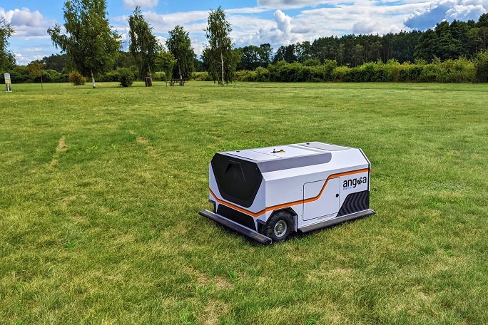 A mobile robot automatically cleans a lawn of small items of waste.
