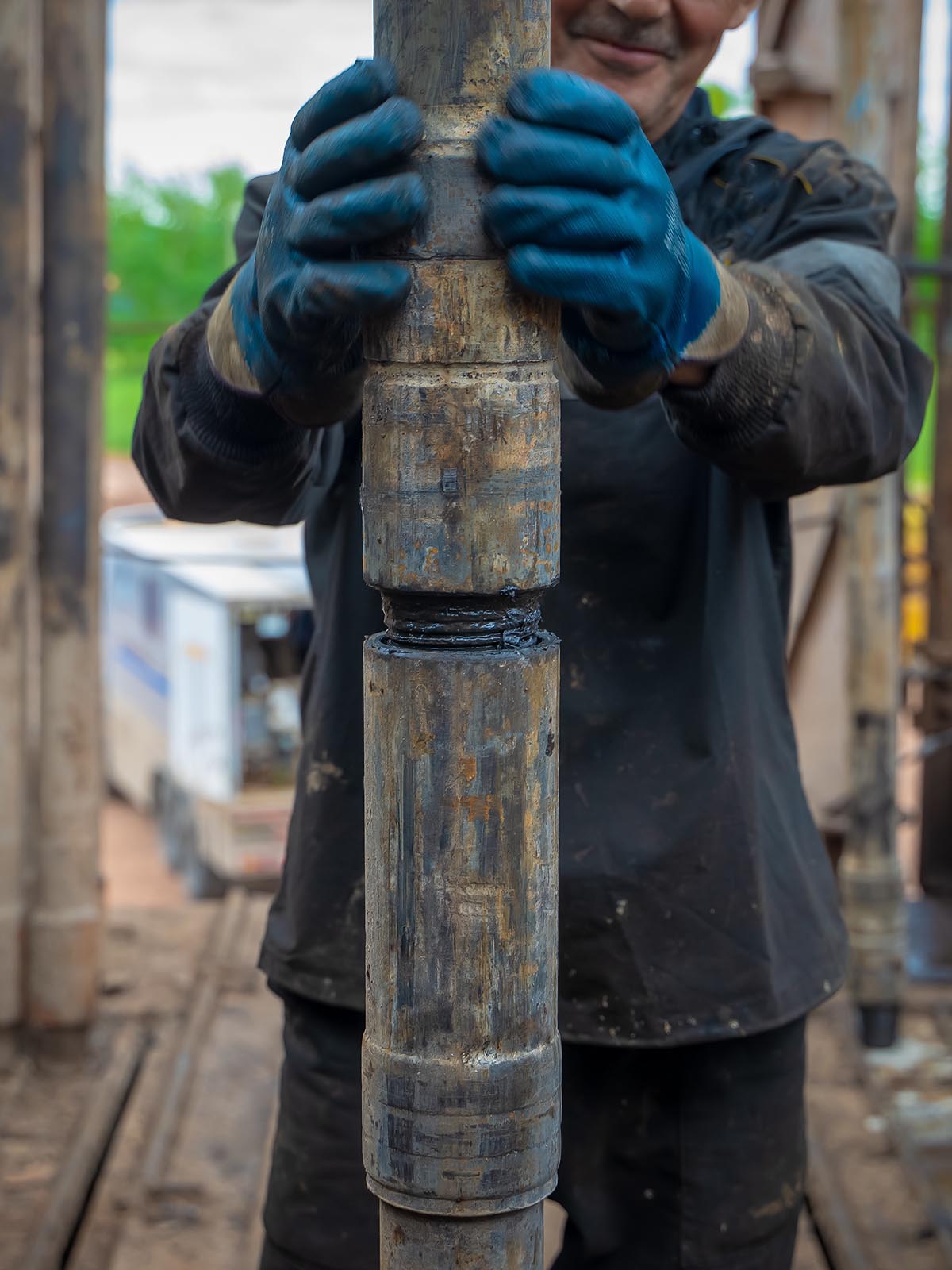 Oil rig worker prepare tool and equipment for perforation oil and gas well at wellhead platform. Making up a drill pipe connection. A view for drill pipe connection from between the stands