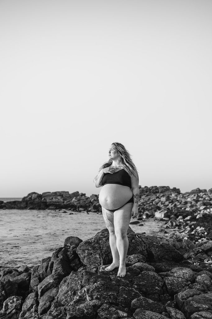 gravid kvinne står ved havet