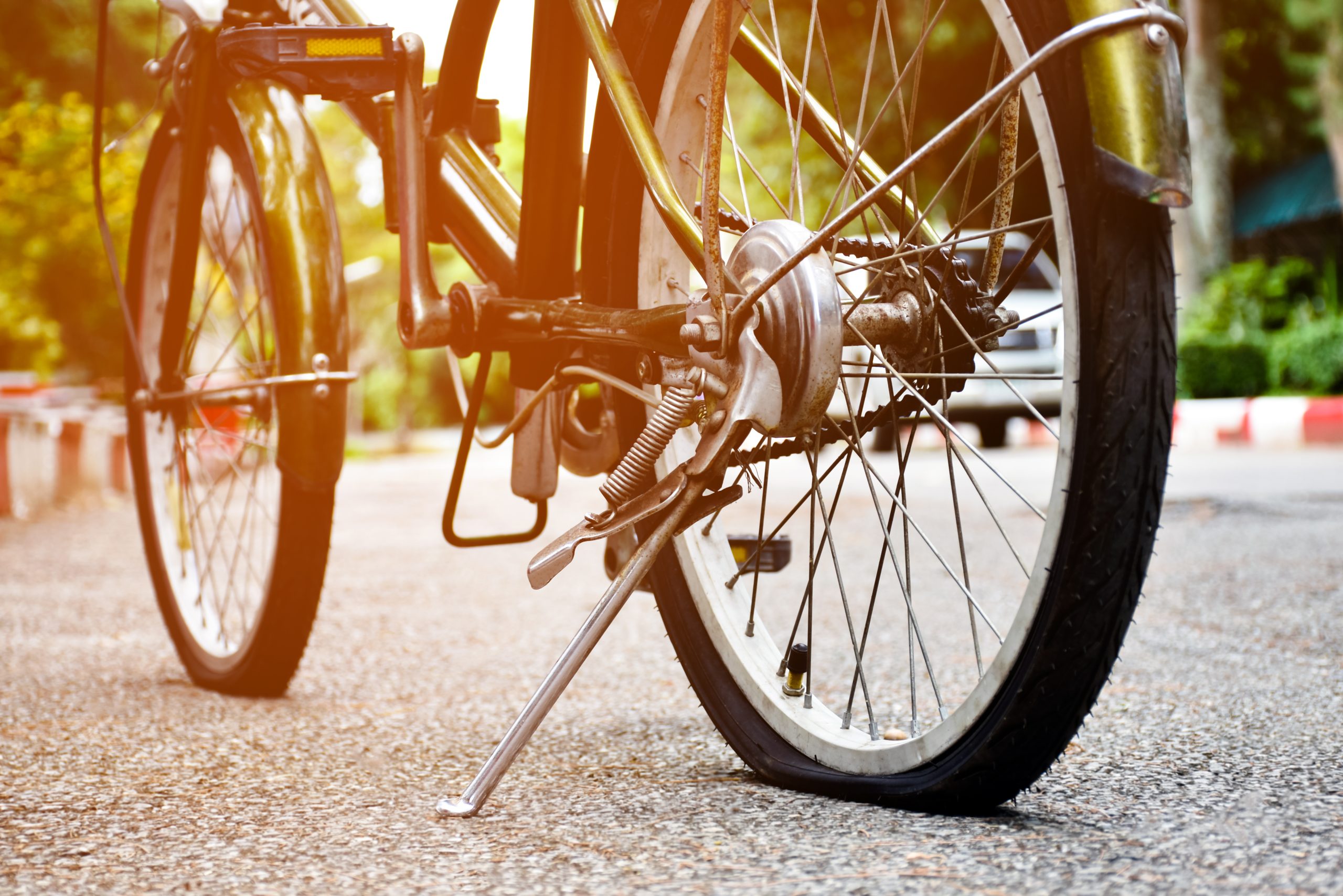 Closeup view of rear wheel of old bicycle which is flat and park