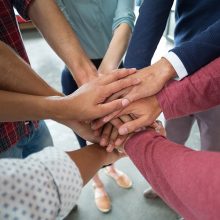 Team of businesspeople forming hand stack in office