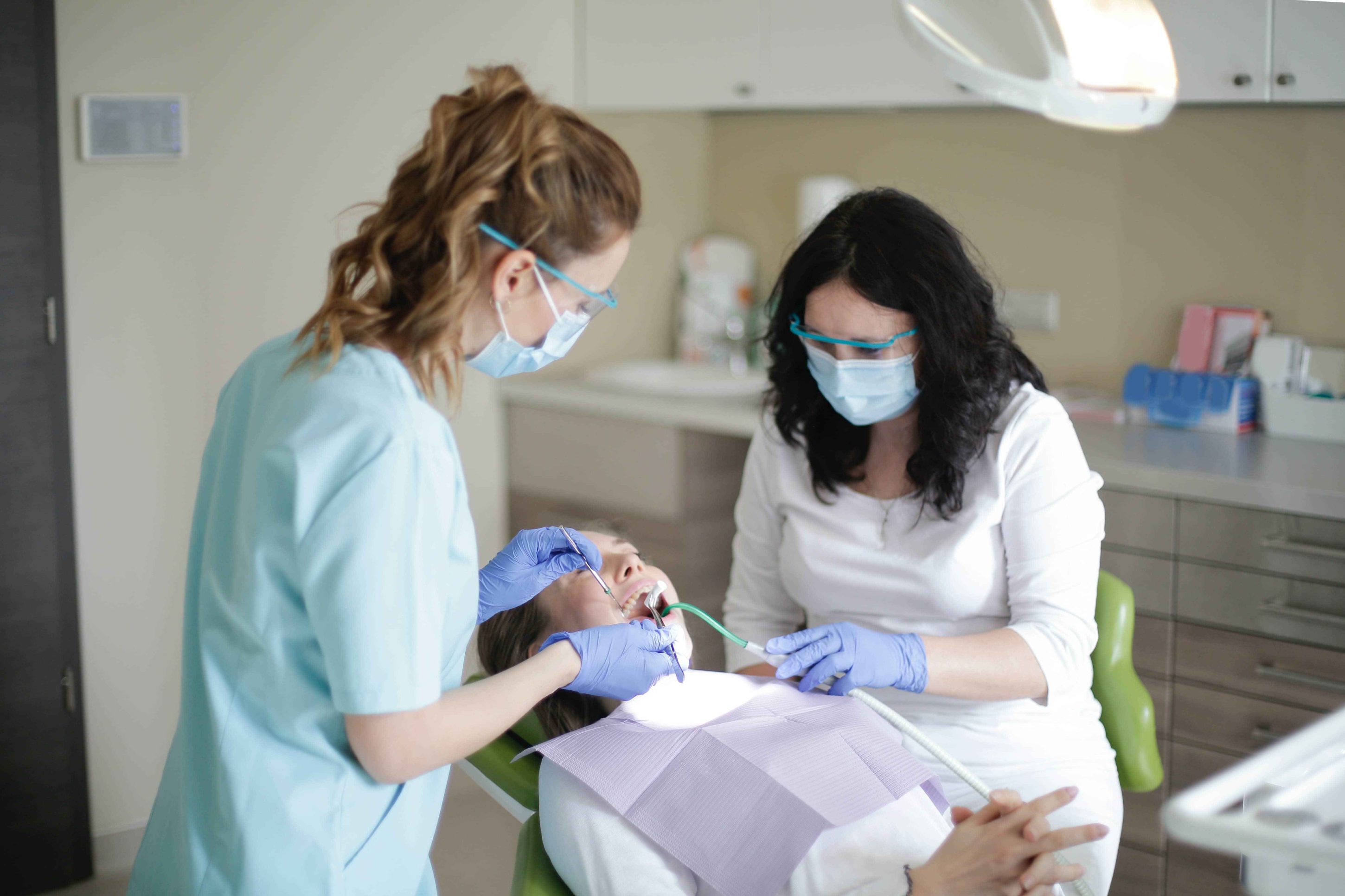 Soin d'une femme au dentiste et son assistante