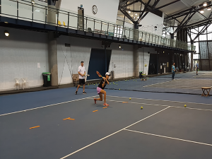 Photo of Blind tennis player playing tennis on indoor tennis court.